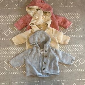 Three knit baby sweaters